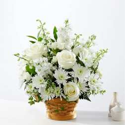 White roses and daisies arranged in a woven basket