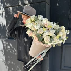 Large bouquet of white and blush flowers in a beige hatbox