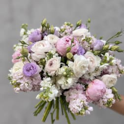 Handheld bouquet of pale pink, white, and lavender flowers
