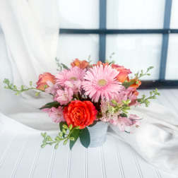 Pink and orange mixed bouquet in a small ribbed vase