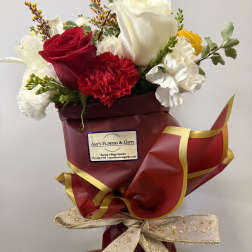 Bouquet of red and white roses with carnations wrapped in burgundy paper