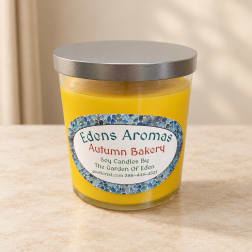 Yellow candle in a glass jar with a silver lid and printed label