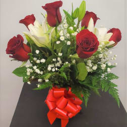 Bouquet of red roses and white lilies with a red ribbon bow