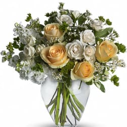 Bouquet of cream and white roses in a clear glass vase