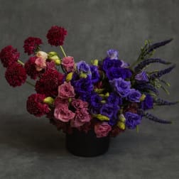 Bouquet of purple and pink flowers in a black container