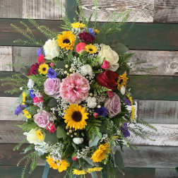 Colorful standing floral wreath on an easel with sunflowers and roses