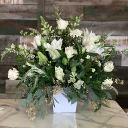 White roses and lilies arranged in a white vase
