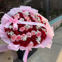 Large bouquet of red and pink roses with a pink birthday ribbon