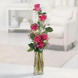 Tall pink rose arrangement in a clear glass vase