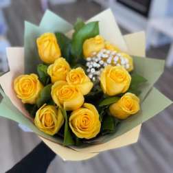 Bouquet of yellow roses wrapped in pastel paper