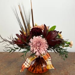 Autumn bouquet with pink and burgundy flowers in an amber vase
