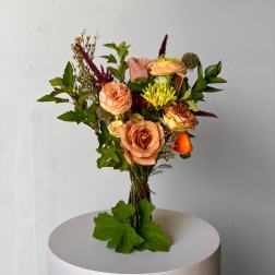 Mixed bouquet of peach and yellow flowers with greenery