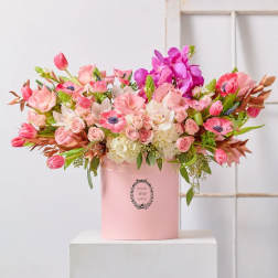 Pink and white mixed flower arrangement in a pink hat box