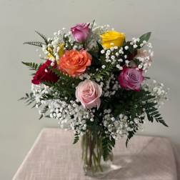 Mixed roses with baby's breath in a clear glass vase
