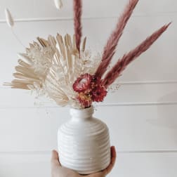 Dried floral arrangement in a white vase with pink and cream pampas grass