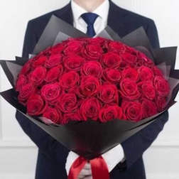 Large bouquet of red roses wrapped in black paper with a red ribbon