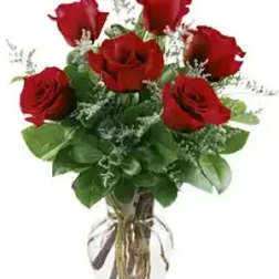 Bouquet of red roses with greenery in a clear vase