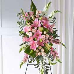 Tall pink and white floral standing spray on a black easel