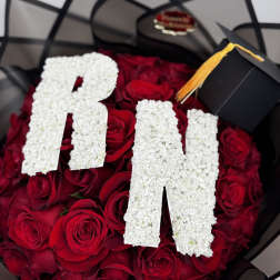 Red rose bouquet with white floral letters and a graduation cap topper