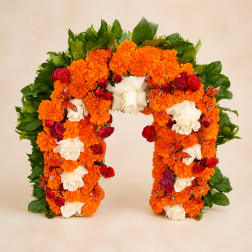 Floral arch covered in orange marigolds, white roses, and red roses