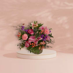 Pink and purple mixed flower arrangement in a glass vase