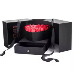 Red roses in a black gift box with ribbon handles
