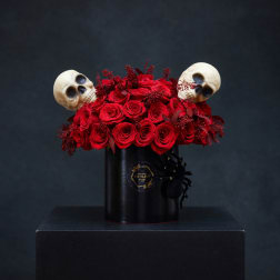 Red roses in a black hatbox with two skull decorations