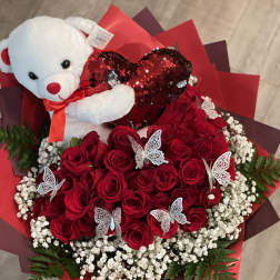 Red rose bouquet with a teddy bear holding a heart and butterfly picks