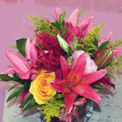 Pink lilies and a yellow rose in a glass vase