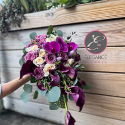 Bouquet of purple roses and calla lilies with eucalyptus