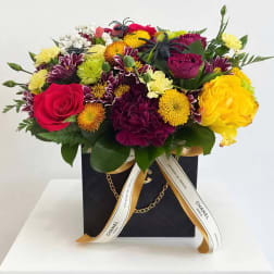 Mixed bouquet of roses and chrysanthemums in a black gift box with ribbon