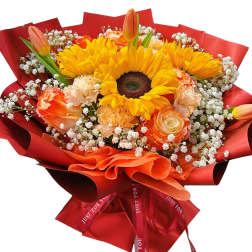 Bouquet of sunflowers, roses, carnations, and tulips wrapped in red paper