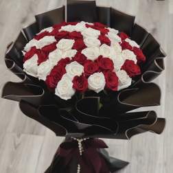 Bouquet of red and white roses wrapped in black paper