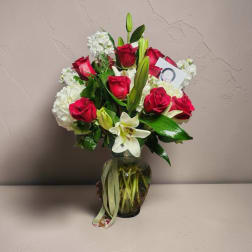 Red roses and white lilies arranged in a glass vase