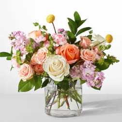 Mixed pink and peach roses in a clear glass vase