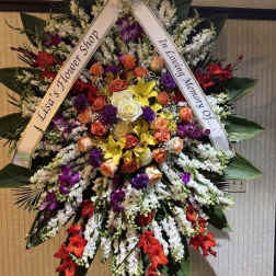 Large standing sympathy wreath with mixed roses and orchids on a ribboned easel