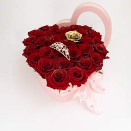 Heart-shaped box of red roses with a pink ribbon and jeweled tiara