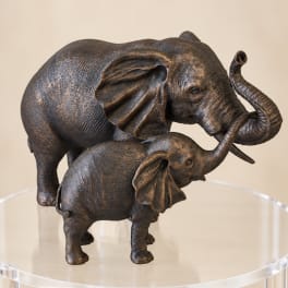 Two bronze elephant figurines on a clear round stand