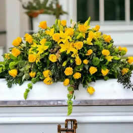 Yellow floral casket spray with roses and lilies