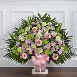 Large floral standing spray with pink roses and lavender daisies on a white stand