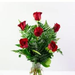 Red roses arranged in a clear glass vase