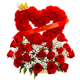 Red heart-shaped floral arrangement with roses and a crown topper