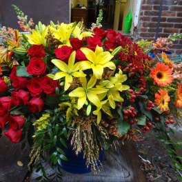 Large bouquet of red roses and yellow lilies with orange daisies