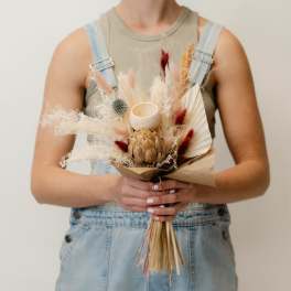 Dried bouquet with a protea, pampas grass, and a small candle