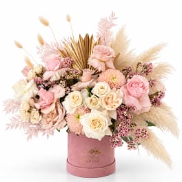 Pink and cream roses in a pink hatbox with dried pampas grass