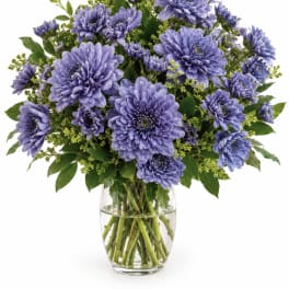 Purple chrysanthemum bouquet in a clear glass vase