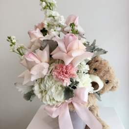 Pink and white bouquet with a teddy bear in a vase