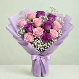 Bouquet of pink and purple roses wrapped in lavender paper