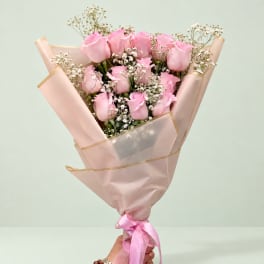 Pink rose bouquet wrapped in blush paper with a ribbon