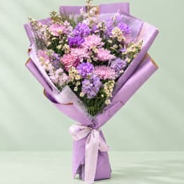 Lavender bouquet of pink and purple flowers wrapped in lilac paper